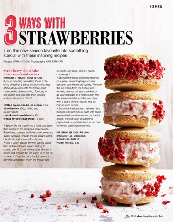 Creative food photography showing a stack of strawberry shortcake ice cream sandwiches decorated with freeze dried strawberries
