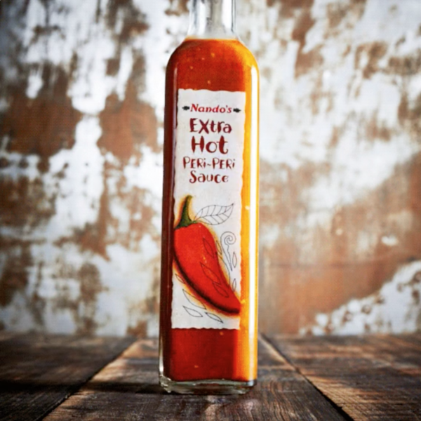 Food videography showing a bottle of extra hot peri-peri sauce
