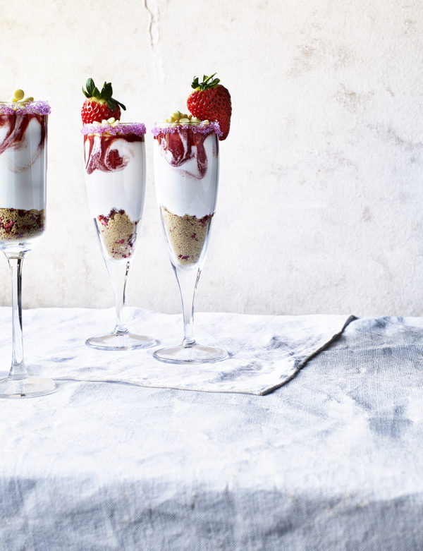 Food photography showing three flutes of a strawberry and cream dessert