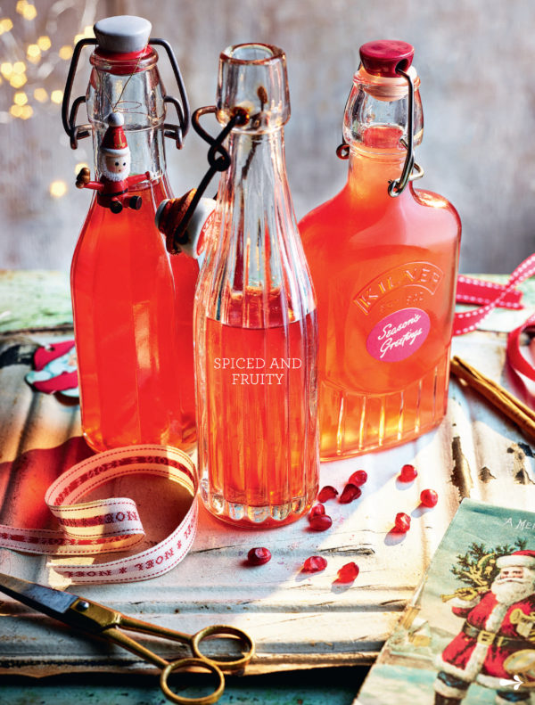 Food photography showing three different shaped bottles of pomegranate juice, with ribbons ready to decorate and give as gifts