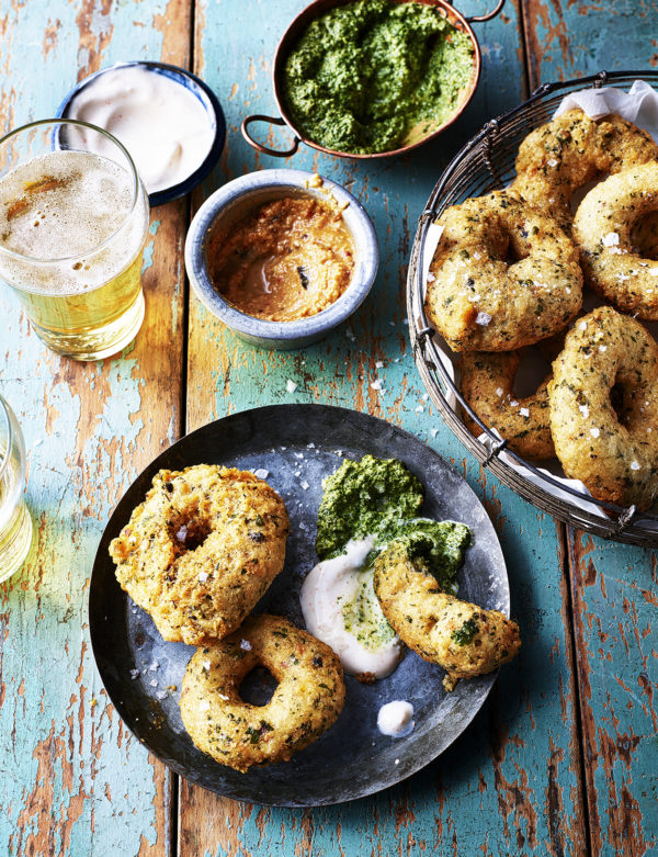 Food photography showing a plate of three lentil doughnuts, with a yogurt dip