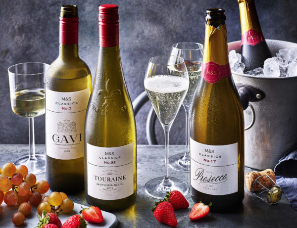 Food photography showing four different bottles of wine, one of which is on a cooler